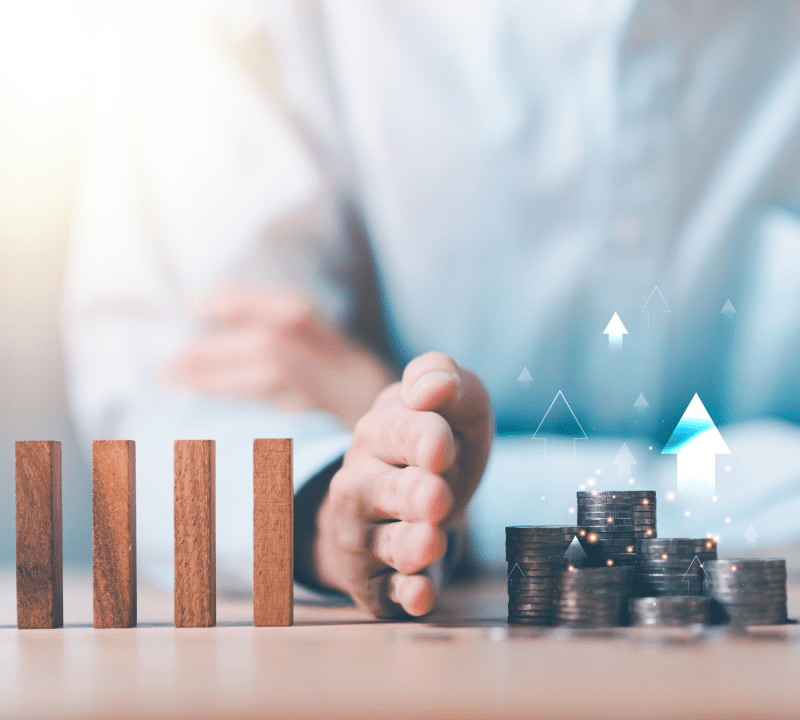 Hand trennt Holzstäbe von einem wachsenden Geldhaufen: Ein Zinssicherungskonto bei uns sichert Ihre Zinsen langfristig ab.